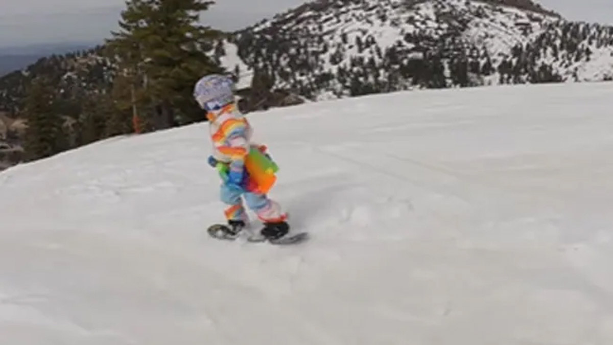 A Little Girl Singing While Snowboarding