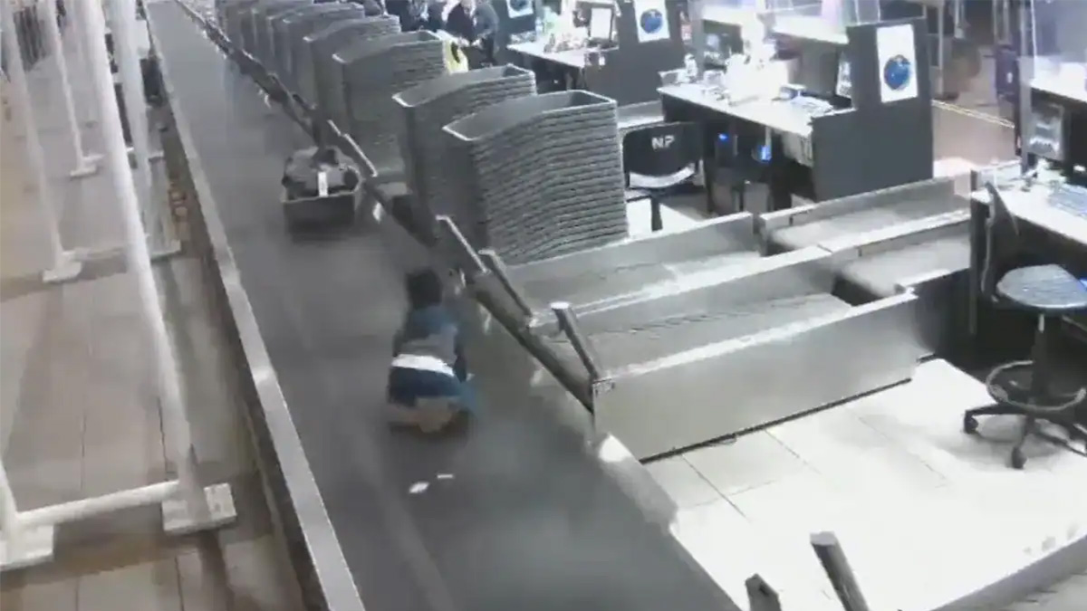 A Child Takes A Wild Ride On An Airport Conveyor Belt
